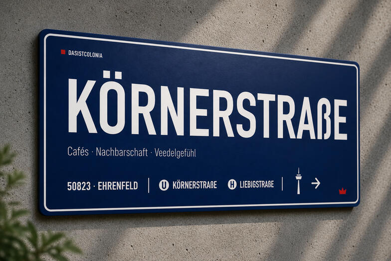 Das Aluminium-Designschild „Körnerstraße“ von DasIstColonia in Dunkelblau mit weißer Typografie an einer Betonwand. Design Straßenschild für Köln-Liebhaber